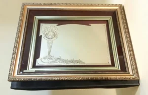 Plaqueta conmemorativa tipo cuadro con acabado en oro, marco decorativo y estuche de lujo de Nevey Medallas.