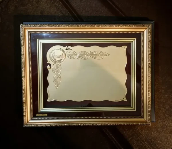 Plaqueta conmemorativa tipo cuadro con acabado en oro, marco decorativo y estuche de lujo de Nevey Medallas. Modelo 2000