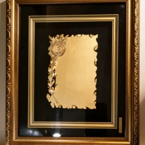 Plaqueta conmemorativa tipo cuadro con acabado en oro, marco decorativo y estuche de lujo de Nevey Medallas. Modelo 2100