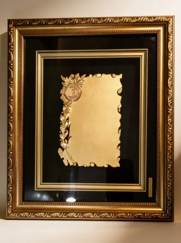 Plaqueta conmemorativa tipo cuadro con acabado en oro, marco decorativo y estuche de lujo de Nevey Medallas. Modelo 2100