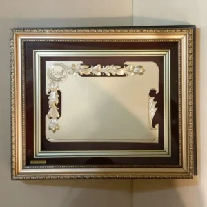 Plaqueta conmemorativa tipo cuadro con acabado en oro, marco decorativo y estuche de lujo de Nevey Medallas. Modelo 4200
