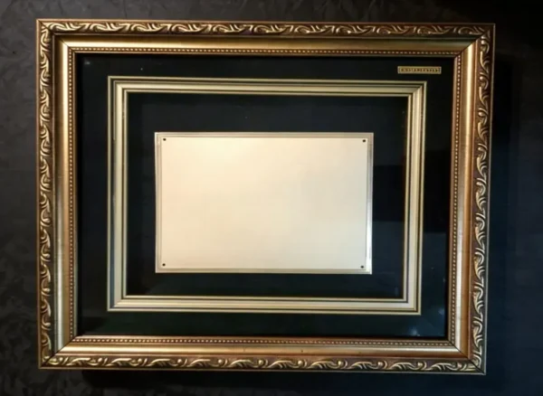 Plaqueta conmemorativa tipo cuadro con acabado en oro, marco decorativo y estuche de lujo de Nevey Medallas. Modelo 5200 rotulo