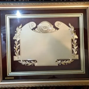 Plaqueta conmemorativa tipo cuadro con acabado en oro, marco decorativo y estuche de lujo de Nevey Medallas. Modelo 5600