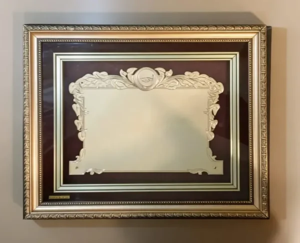 Plaqueta conmemorativa tipo cuadro con acabado en oro, marco decorativo y estuche de lujo de Nevey Medallas. modelo 5900