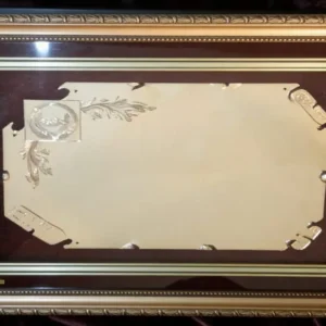 Plaqueta conmemorativa tipo cuadro con acabado en oro, marco decorativo y estuche de lujo de Nevey Medallas. Modelo 6100
